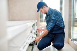 Un installatore professionista esamina attentamente una vasca da bagno in un ambiente luminoso, equipaggiato per rispondere a tutte le domande scomode da porre all'installatore per il bagno e garantire un servizio di qualità.