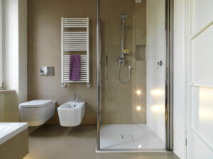 Un moderno bagno dotato di doccia che illustra i vantaggi della doccia rispetto alla vasca, con design efficiente e minimalista per un uso ottimale dello spazio e della risorsa idrica.